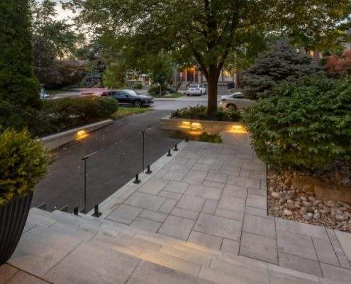 custom retaining wall with glass railings lighting toronto